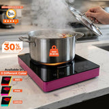 Stainless steel pot on a portable stove with steam rising, on a kitchen counter.